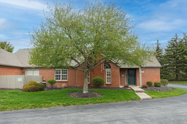 3870 Sandstone Cir, Powell, OH 43065 - view of front of house featuring brick siding, a front lawn, fence, and a shingled roof
