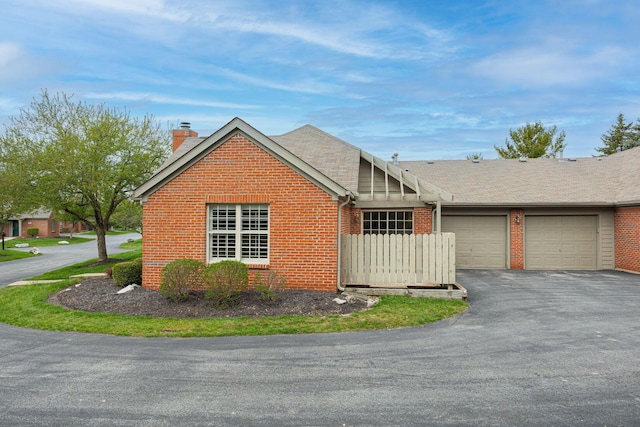 3870 Sandstone Cir, Powell, OH 43065 - view of front of home with a chimney, aphalt driveway, fence, a garage, and brick siding