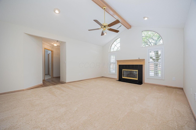 3870 Sandstone Cir, Powell, OH 43065 - unfurnished living room featuring beam ceiling, carpet, ceiling fan, a tile fireplace, and high vaulted ceiling