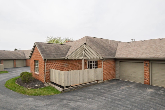 3870 Sandstone Cir, Powell, OH 43065 - view of front of property featuring fence, roof with shingles, driveway, brick siding, and a garage