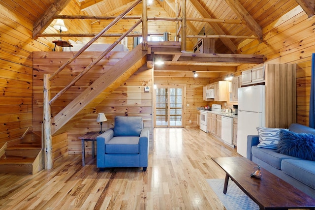 unfurnished living room with wood walls, high vaulted ceiling, wood ceiling, beamed ceiling, and light wood finished floors