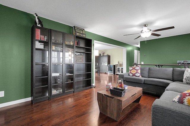 living area with baseboards, wood finished floors, and a ceiling fan