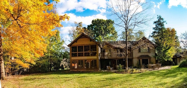 rear view of property with a yard and a patio