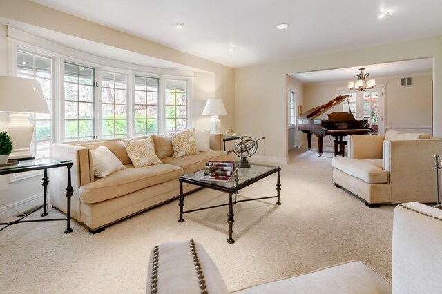 carpeted living area featuring baseboards, a chandelier, visible vents, and recessed lighting