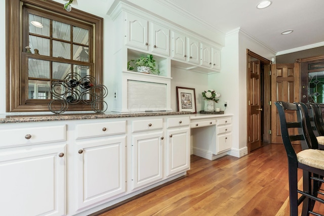 bar featuring light wood finished floors, baseboards, recessed lighting, and crown molding