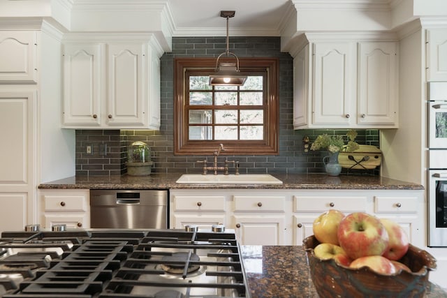 kitchen featuring dishwasher, white cabinets, decorative backsplash, and a sink