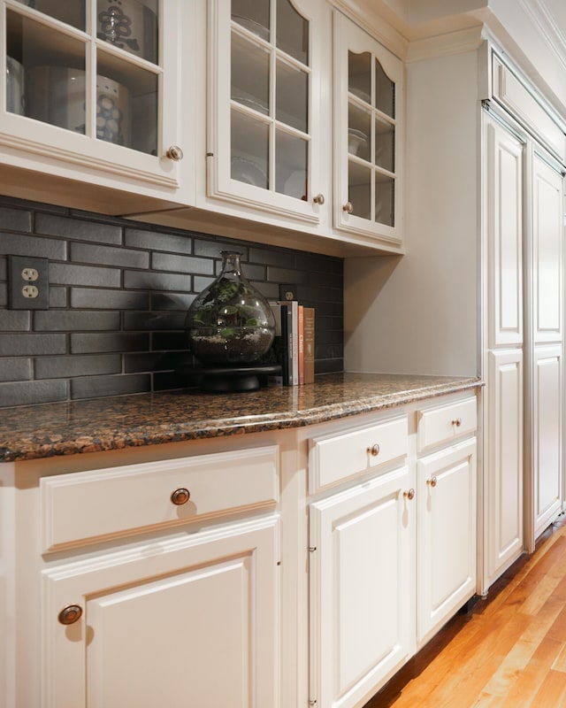 bar featuring decorative backsplash and light wood-style floors