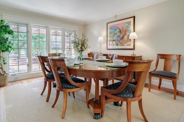 dining space featuring plenty of natural light, wood finished floors, and ornamental molding