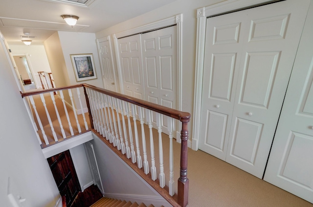 stairs featuring attic access, baseboards, and carpet