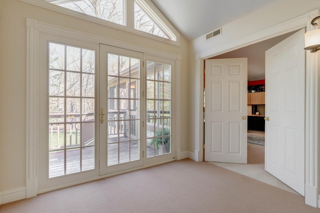 doorway with vaulted ceiling, carpet, and visible vents