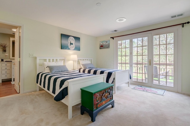 carpeted bedroom with visible vents, multiple windows, and access to exterior