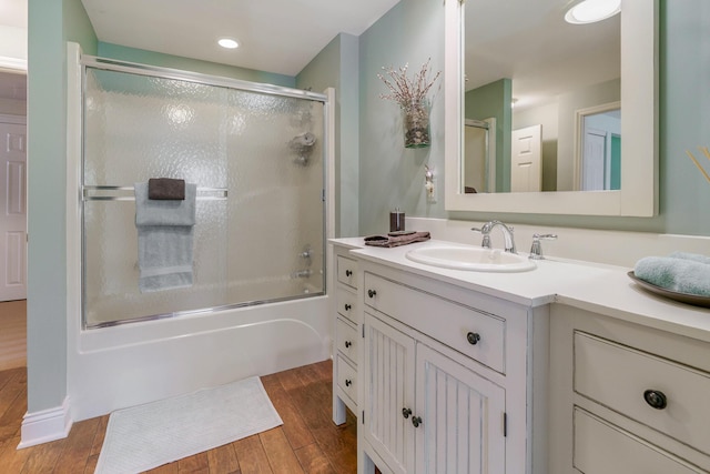 bathroom featuring shower / bath combination with glass door, wood finished floors, vanity, and recessed lighting