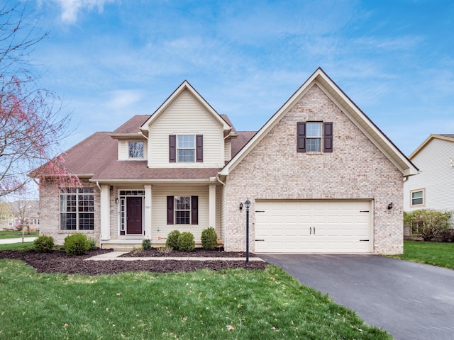traditional-style house with brick siding, a front lawn, an attached garage, and driveway