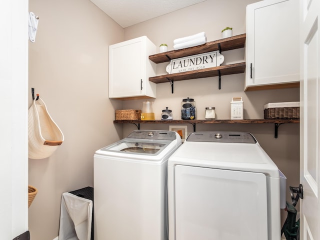 clothes washing area featuring washer and dryer and cabinet space