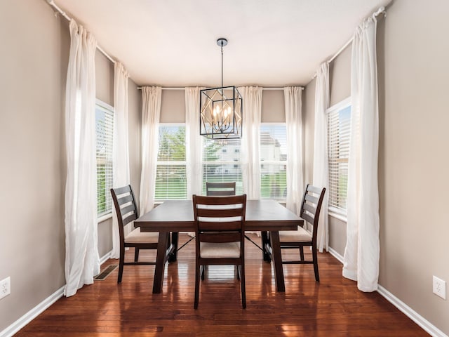 dining area with visible vents, baseboards, a chandelier, and dark wood finished floors