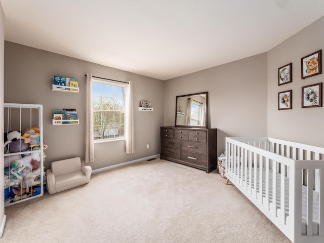 carpeted bedroom featuring baseboards and a nursery area