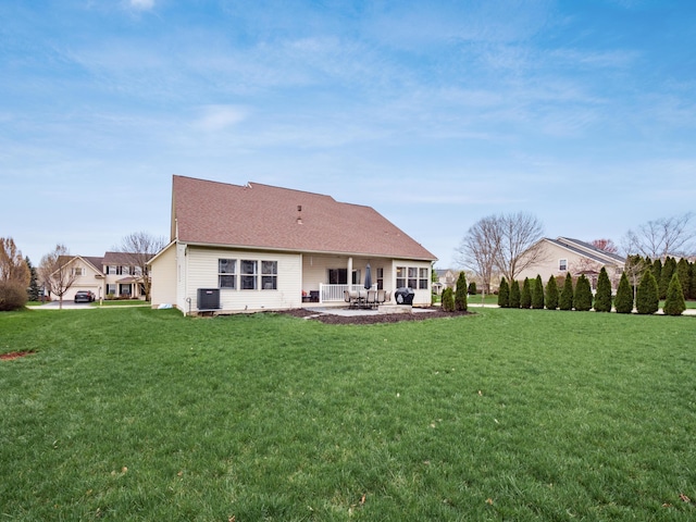 back of property featuring a patio, roof with shingles, cooling unit, and a lawn