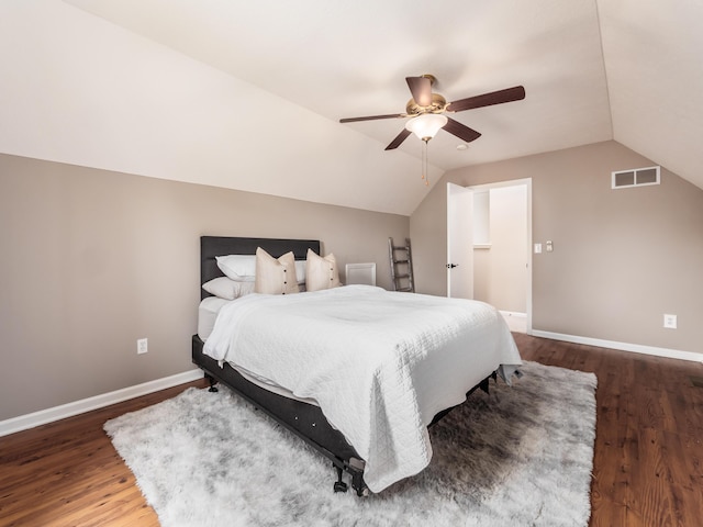 bedroom featuring wood finished floors, baseboards, vaulted ceiling, and visible vents