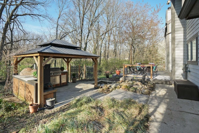 view of patio / terrace with grilling area, an outdoor kitchen, and a gazebo