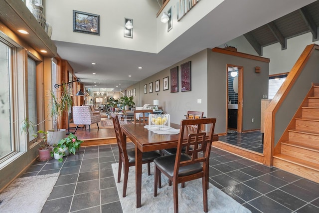 dining space featuring recessed lighting, tile patterned flooring, stairs, and a high ceiling