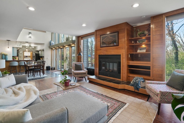 living area with recessed lighting, a large fireplace, and wood finished floors