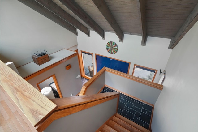 stairway with wood ceiling, wood finished floors, and beamed ceiling