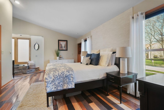 bedroom with baseboards, lofted ceiling, and hardwood / wood-style floors