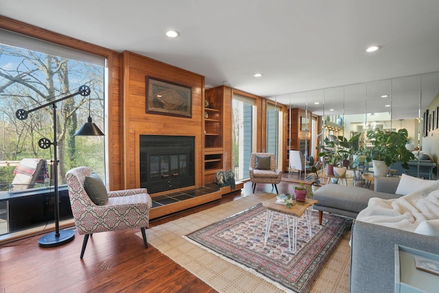 living room featuring recessed lighting, floor to ceiling windows, wood finished floors, and a fireplace