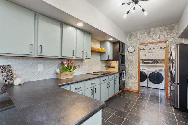 kitchen featuring dark countertops, open shelves, black oven, freestanding refrigerator, and washer and clothes dryer