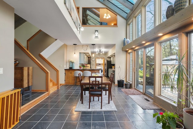 dining area featuring a high ceiling, stairs, and a notable chandelier