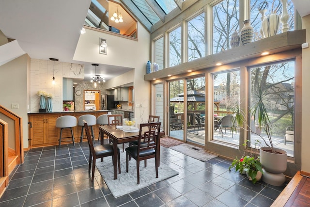 dining room with a high ceiling, a chandelier, and baseboards