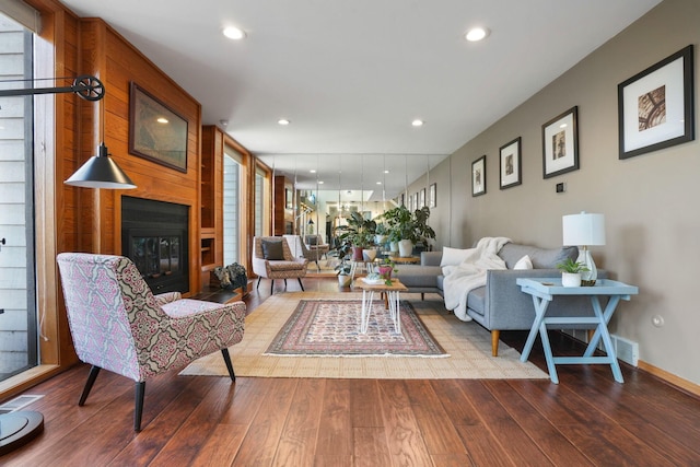 living room featuring recessed lighting, a large fireplace, and wood finished floors