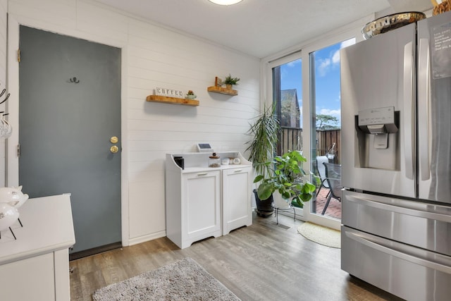 laundry area featuring wood walls and light wood-style flooring
