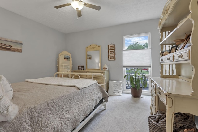 carpeted bedroom with a ceiling fan and a textured ceiling