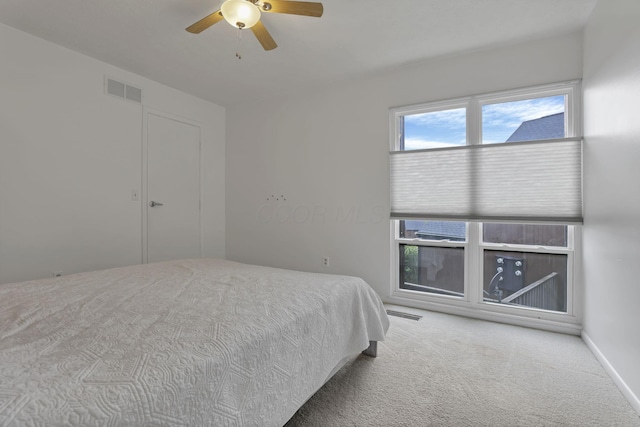 carpeted bedroom with visible vents and ceiling fan