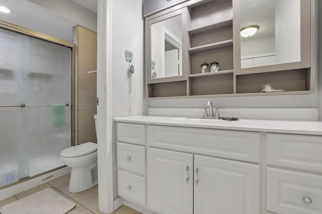 bathroom with vanity, toilet, tile patterned floors, and a stall shower