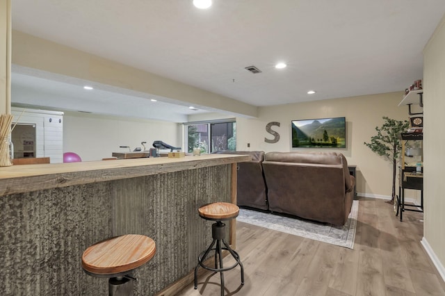 bar with visible vents, baseboards, recessed lighting, light wood-type flooring, and wet bar