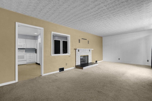 unfurnished living room with a fireplace, a textured ceiling, baseboards, visible vents, and carpet