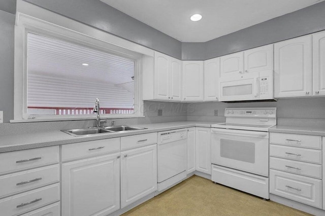 kitchen featuring light countertops, white cabinets, a sink, and white appliances