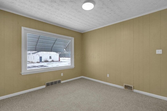 empty room with carpet floors, a textured ceiling, and visible vents