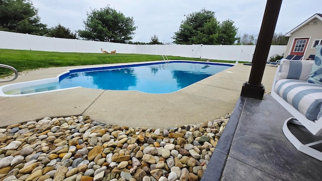 view of swimming pool featuring a fenced in pool, a fenced backyard, a yard, and a patio