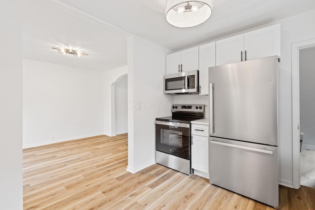 1381 Oakwood Ave, Columbus, OH 43206 - kitchen featuring arched walkways, light wood-style flooring, a chandelier, and appliances with stainless steel finishes
