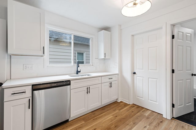 1381 Oakwood Ave, Columbus, OH 43206 - kitchen featuring backsplash, a sink, stainless steel dishwasher, white cabinets, and light wood-style floors
