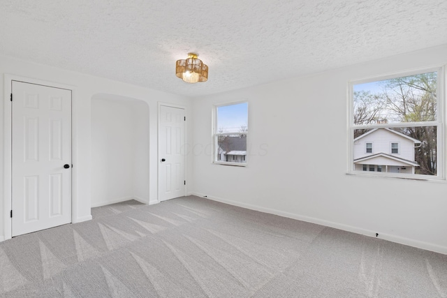 1381 Oakwood Ave, Columbus, OH 43206 - empty room featuring baseboards, arched walkways, carpet, and a textured ceiling