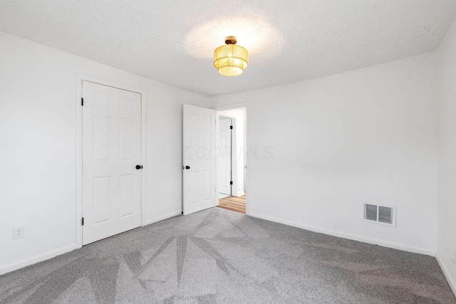 1381 Oakwood Ave, Columbus, OH 43206 - unfurnished bedroom with baseboards, carpet flooring, a textured ceiling, and visible vents