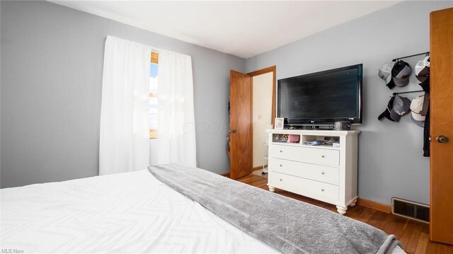bedroom featuring hardwood / wood-style floors, baseboards, and visible vents