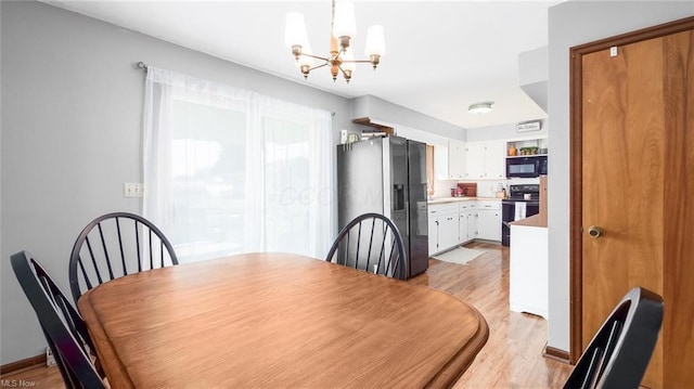 dining space featuring baseboards, an inviting chandelier, and light wood-style floors
