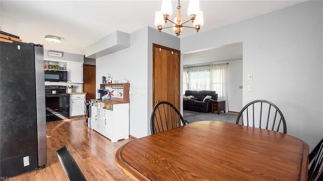 dining room featuring light wood finished floors, baseboards, and a chandelier