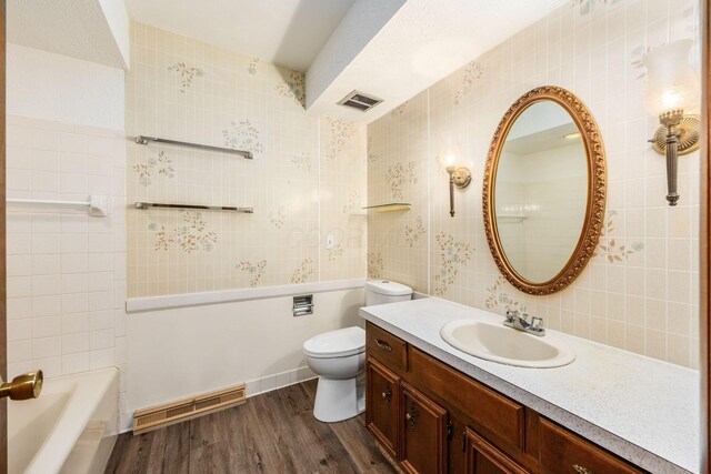 306 Northview Dr, London, OH 43140 - full bathroom featuring vanity, a washtub, wood finished floors, and visible vents