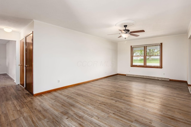 306 Northview Dr, London, OH 43140 - empty room featuring a ceiling fan, crown molding, wood finished floors, baseboards, and a baseboard heating unit